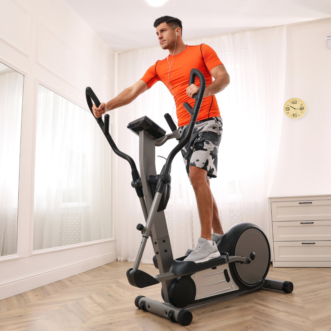 Man exercising on an elliptical machine in a home setting